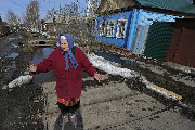 Местная жительница Валентина Щербакова показывает затопленный водой приусадебный участок